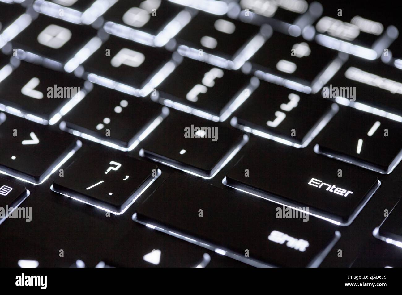 Clavier d'ordinateur rétroéclairé, arrière-plan technologique noir et blanc, gros plan du clavier éclairé. Banque D'Images
