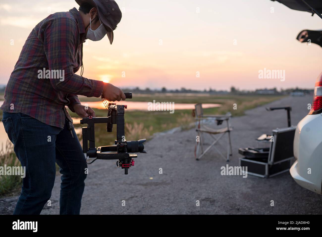 Homme utilisant une nacelle et un stabilisateur pour filmer une vidéo au coucher du soleil Banque D'Images