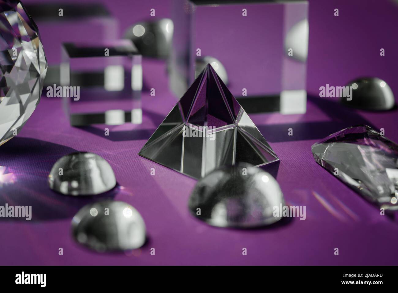 Prisme de cristal réfractant la lumière, les cristaux magiques et la pyramide, la sphère et le cube sur fond violet. Pratique spirituelle de cristal de guérison. Feng Shui, bien Banque D'Images