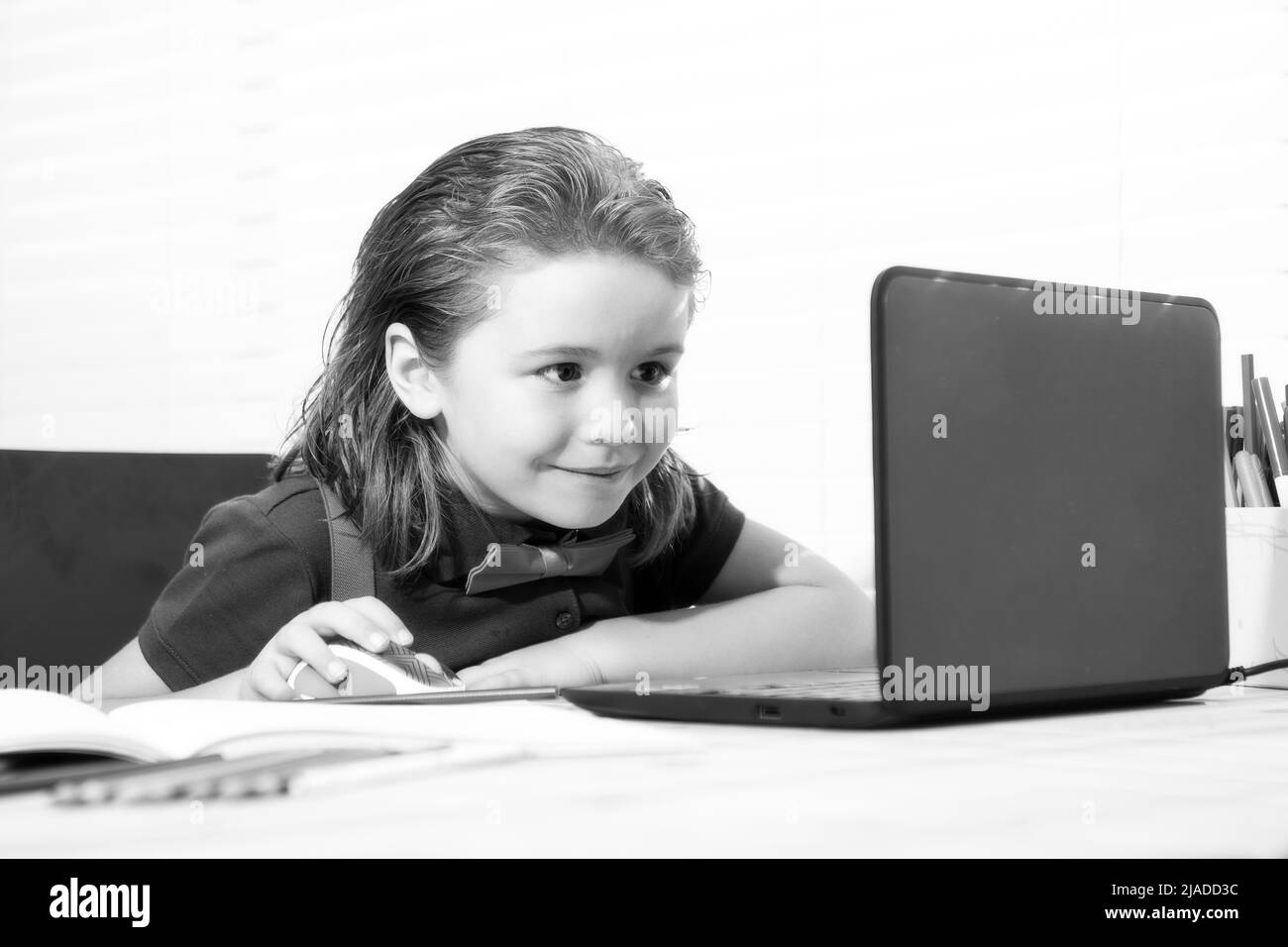 Élève de garçon d'école étudie en ligne. Enseignement à domicile. Apprentissage à distance pour les enfants. Enfant mignon utilisant un ordinateur portable. Éducation, études en ligne, études à domicile, devoirs Banque D'Images