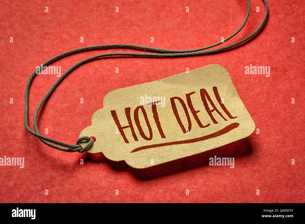 panneau hot deal - étiquette de prix en papier contre le papier rouge texturé, les achats et le concept de marketing Banque D'Images