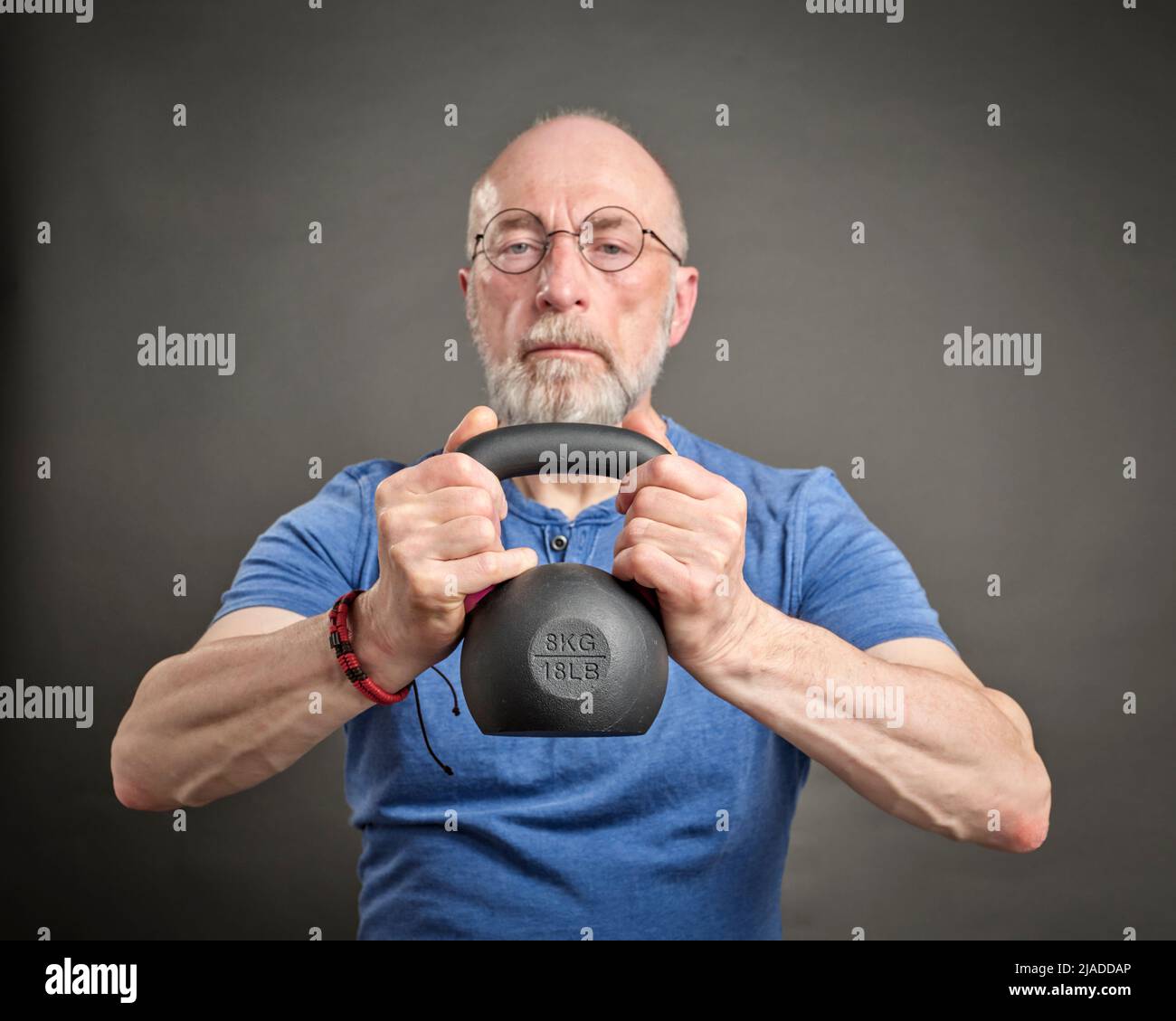 homme senior (fin 60s) s'entraînant avec kettlebell en fer, senior actif et concept de fitness Banque D'Images