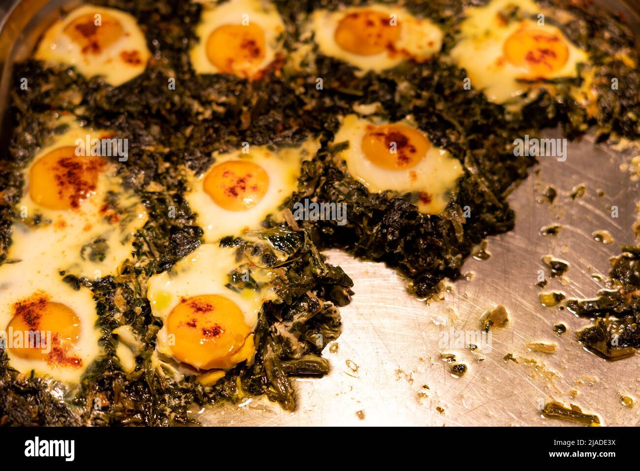 Récipient buffet chauffé avec des œufs simples avec des épinards et de l'ail Banque D'Images