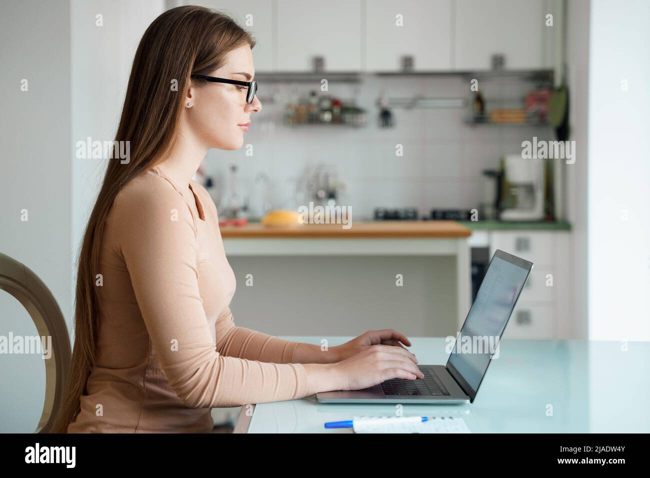 Jeune femme du millénaire travaillant sur un ordinateur portable au bureau à domicile Banque D'Images