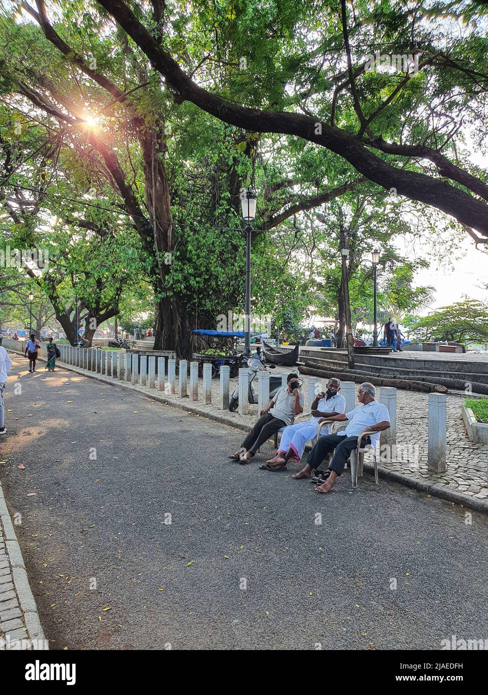 Fort Kochi, Kerala Inde - 11 mars 2022 : un vieil homme bavardant et assis dans la rue à fort Kochi Banque D'Images