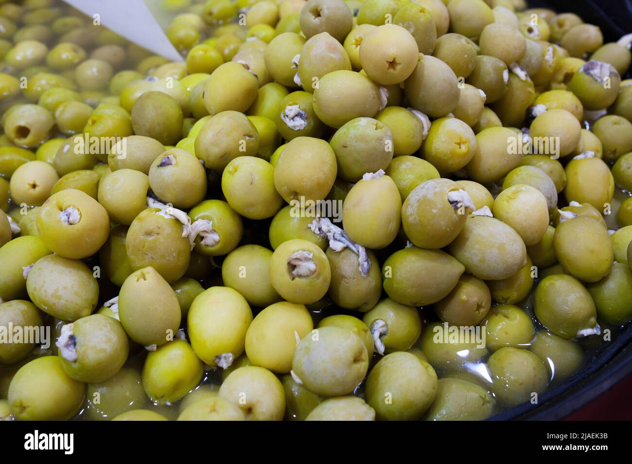 Olives marinées farcies au vinaigre anchois marinés. Panier en plastique en forme d'en-cas marinés délicieux Banque D'Images