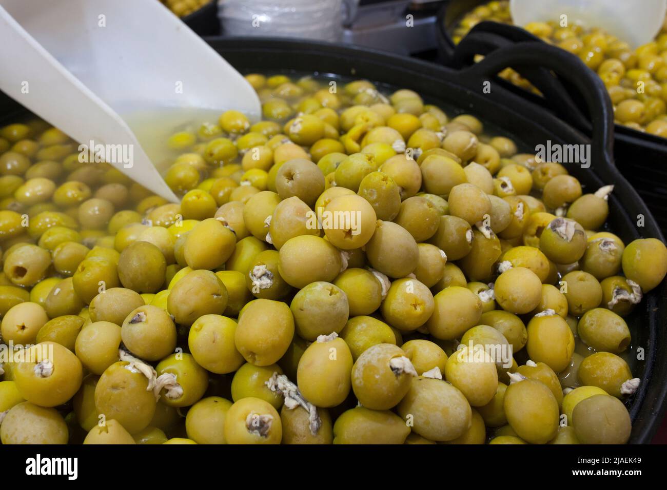 Olives marinées farcies au vinaigre anchois marinés. Panier en plastique en forme d'en-cas marinés délicieux Banque D'Images