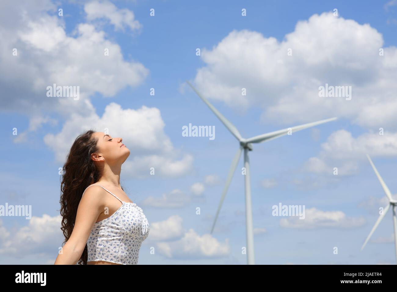 Profil d'une femme qui respirait de l'air frais dans un parc éolien Banque D'Images