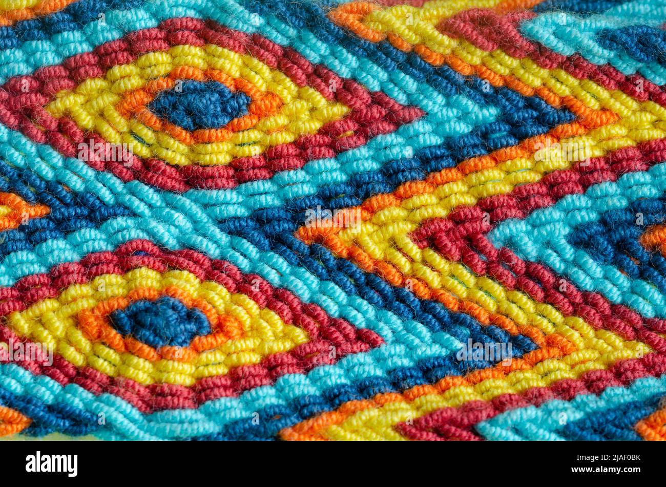Macro de tissage de Wayu fait à la main de couleurs et de formes en zigzag et losange. Textures de concept. Banque D'Images