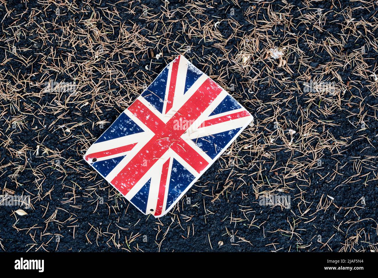 Un morceau de banderole jeté, un drapeau Union Jack, couché sur le trottoir. Banque D'Images