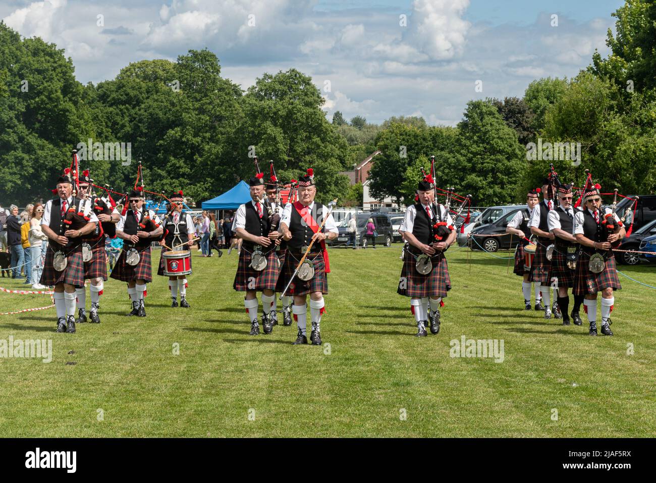 Lecture Scottish Pipe Band en train de marcher dans l'arène et de divertir les gens lors d'un événement à Farnborough, Hampshire, Angleterre, Royaume-Uni Banque D'Images