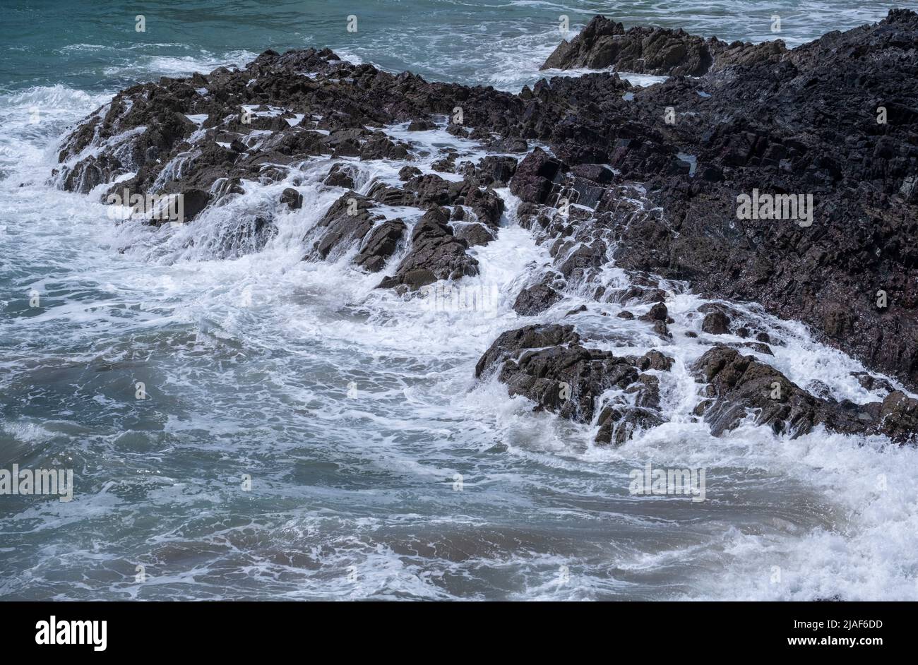 Des vagues écrasant sur les rochers à Kynance, en Cornouailles, en Angleterre. Banque D'Images