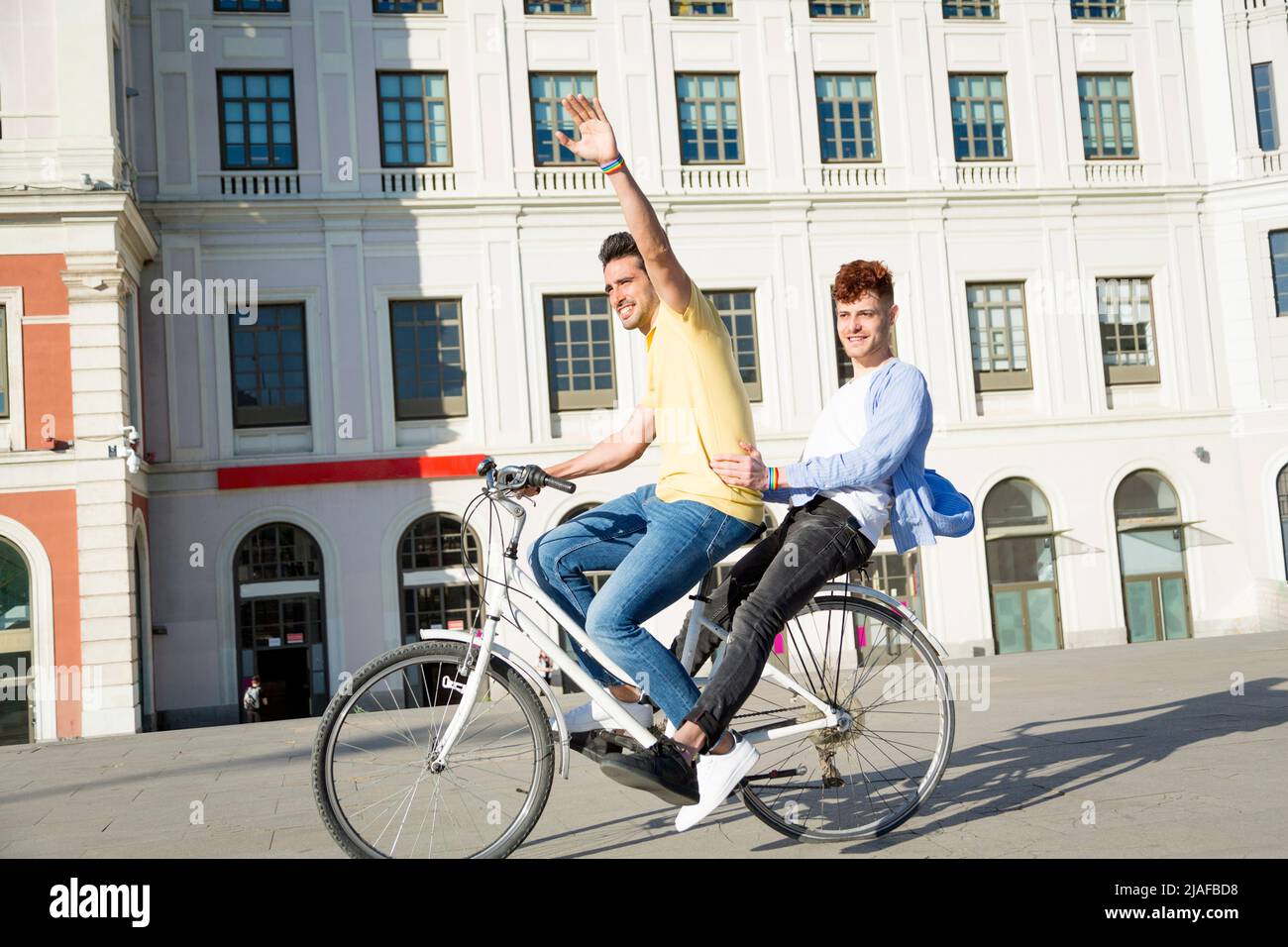 Jeune gay homme couple avec gay fierté bracelets ayant plaisir à faire de l'équitation vélos à l'extérieur. lgbt concept Banque D'Images