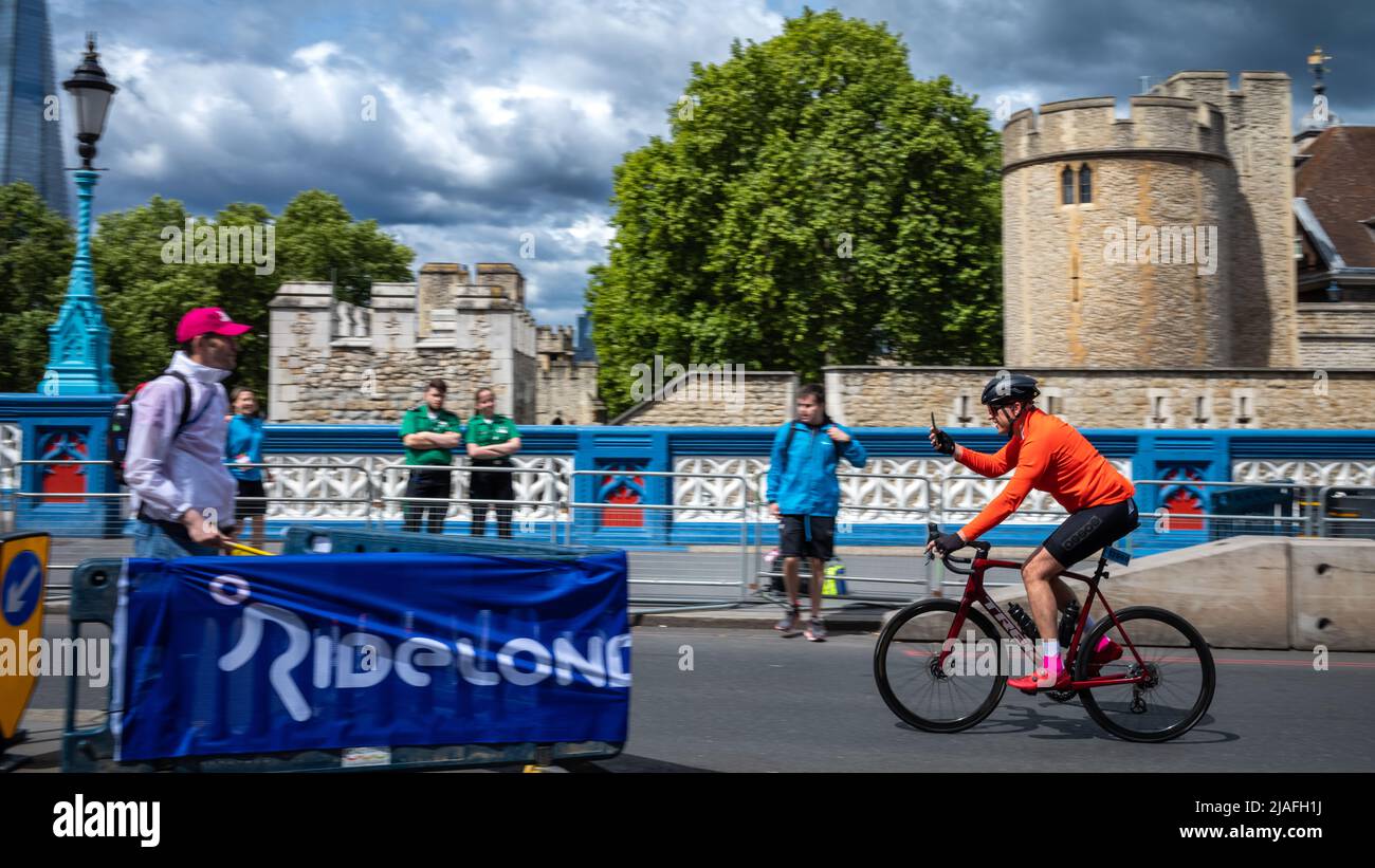 Un cycliste participant à RideLondon 2022 prend un selfie sur son téléphone mobile à l'approche de la ligne d'arrivée sur Tower Bridge à Londres. L'événement Banque D'Images