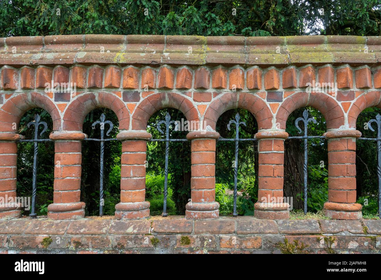 Mur en briques incurvées ornementales avec arches et colonnes et fer forgé Banque D'Images