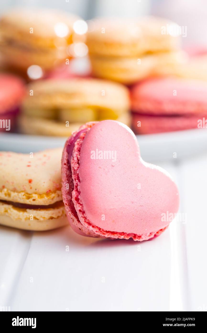 Macarons doux en forme de cœur sur une table blanche. Banque D'Images