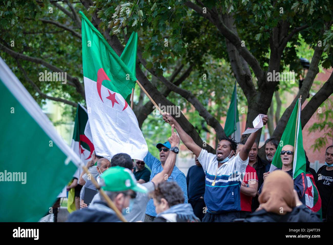 Alexandre Roland, un passant haïtien, qui a reçu un billet par le SPVM (police de Montréal) après avoir sonné le klaxon de sa voiture pour soutenir la manifestation, se joint à d'autres manifestants pour scander des slogans. Quatre ans après son entrée dans la diaspora algérienne, le mouvement Hirak continue de lutter pour la démocratie à Montréal. Organisé par tous nos Unis pour notre Algerie, des centaines de manifestants se sont rassemblés devant le Consulat algérien pour demander la destitution des dirigeants politiques actuels, dirigés par le président Abdelmadjid Tebboune. Invoquant la corruption chronique et l'absence de résolutions prévoyables, les manifestants ont appelé le gov Banque D'Images