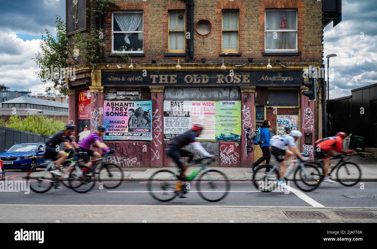 Un groupe de cyclistes participant à RideLondon 2022 passe devant un pub abandonné appelé Old Rose dans l'est de Londres. L'événement a eu lieu pour l'if Banque D'Images