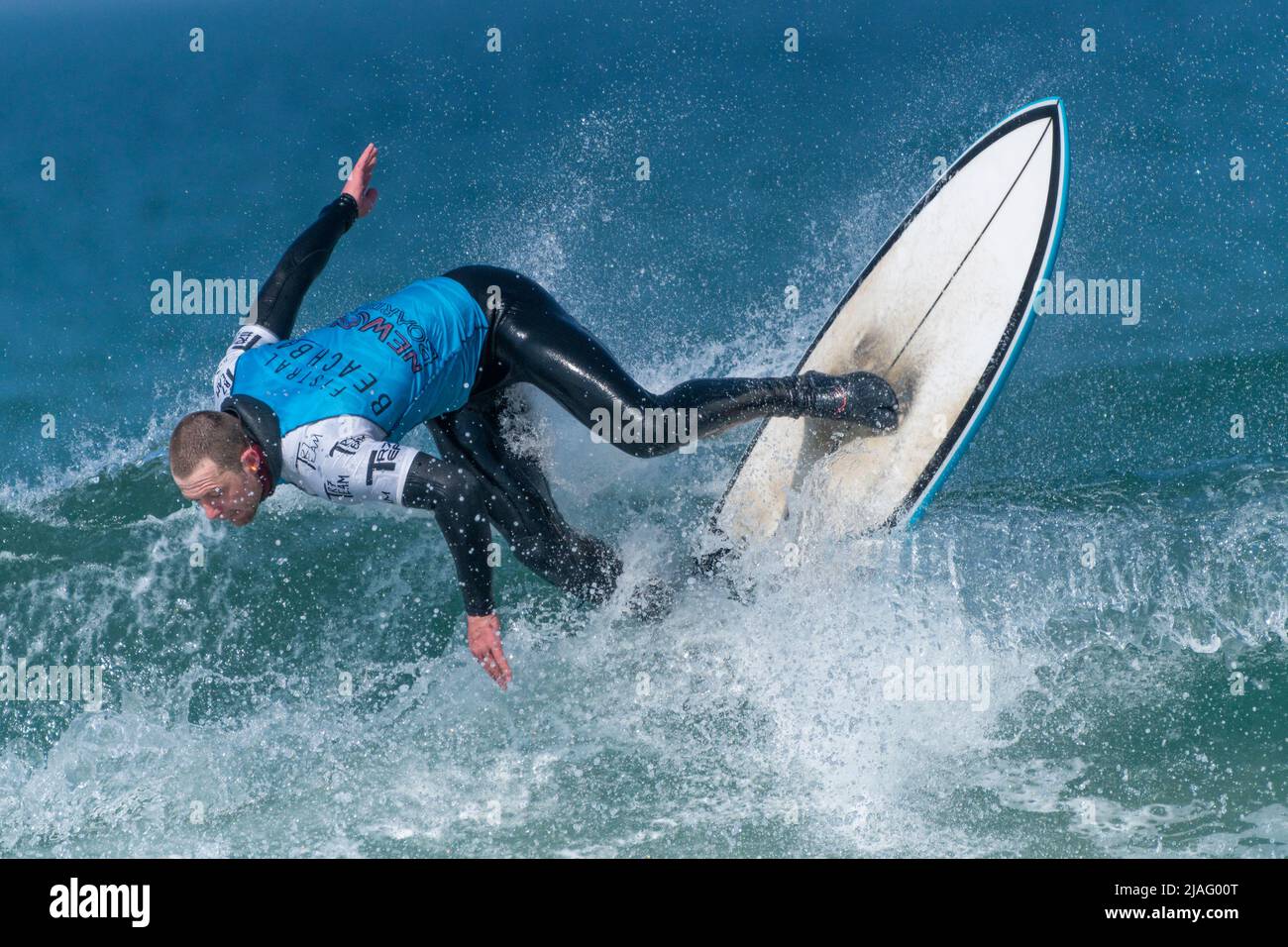 Un surfeur masculin en compétition de surf à Fistral à Newquay, en Cornouailles, au Royaume-Uni. Banque D'Images