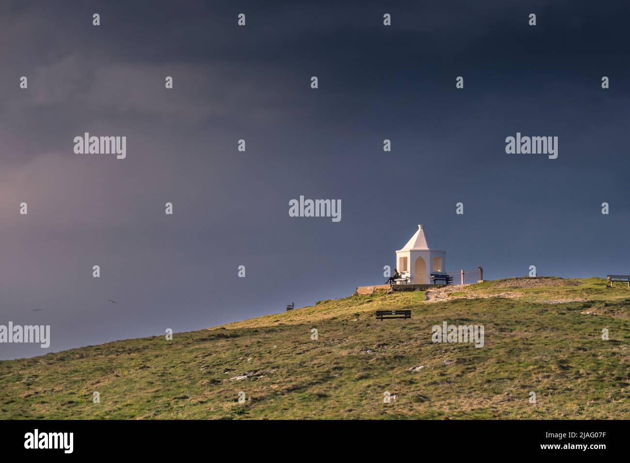 Le petit bâtiment blanc d'observation sur le sommet de Towan Head avec des nuages de pluie foncé qui se rassemblent au-dessus de Newquay, en Cornouailles, au Royaume-Uni. Banque D'Images