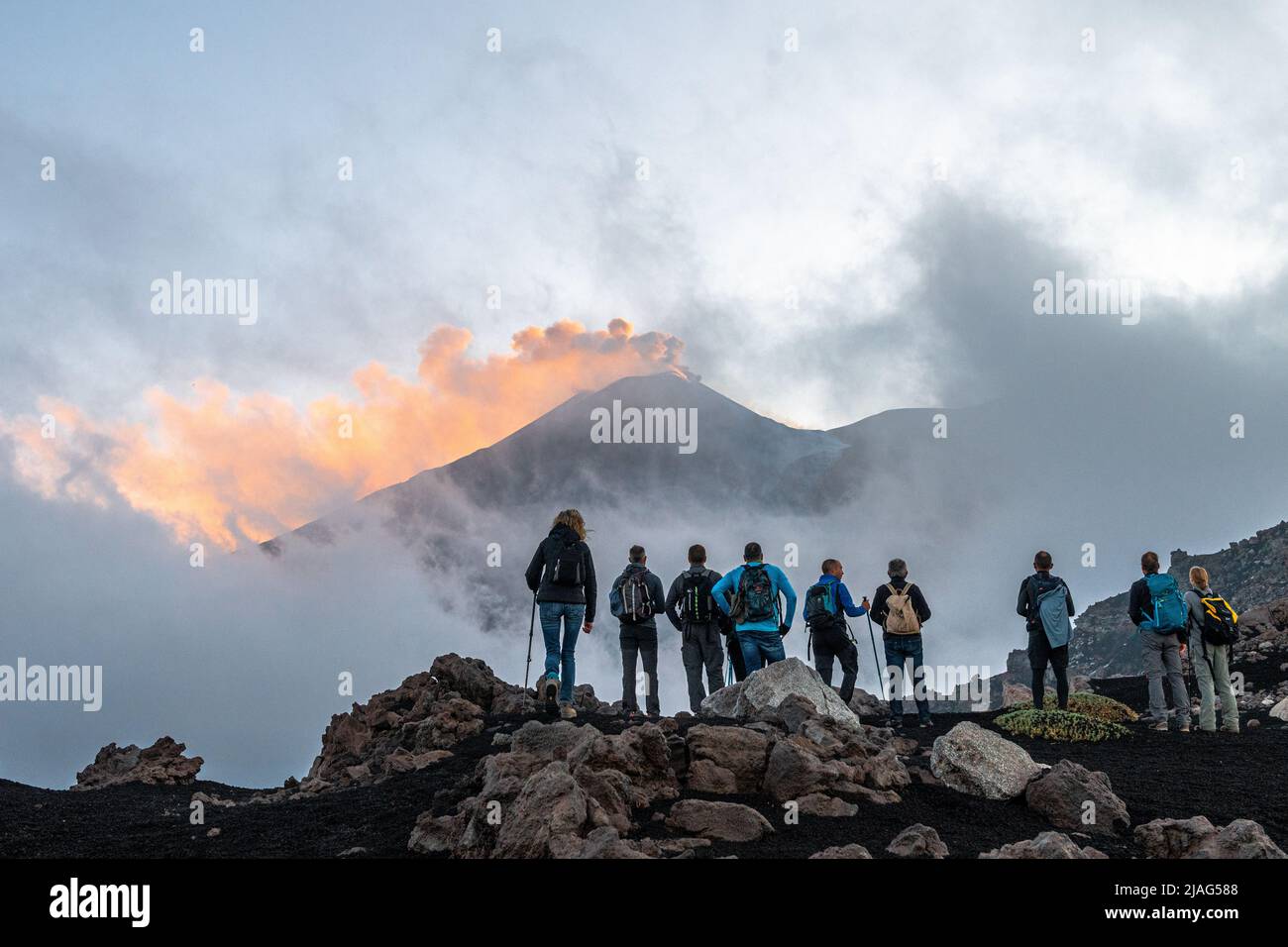 Randonneurs grimpant sur la crête Serra delle Concazze sur l'Etna, pour voir le cratère sud-est actuellement actif du volcan (Sicile, Italie) Banque D'Images