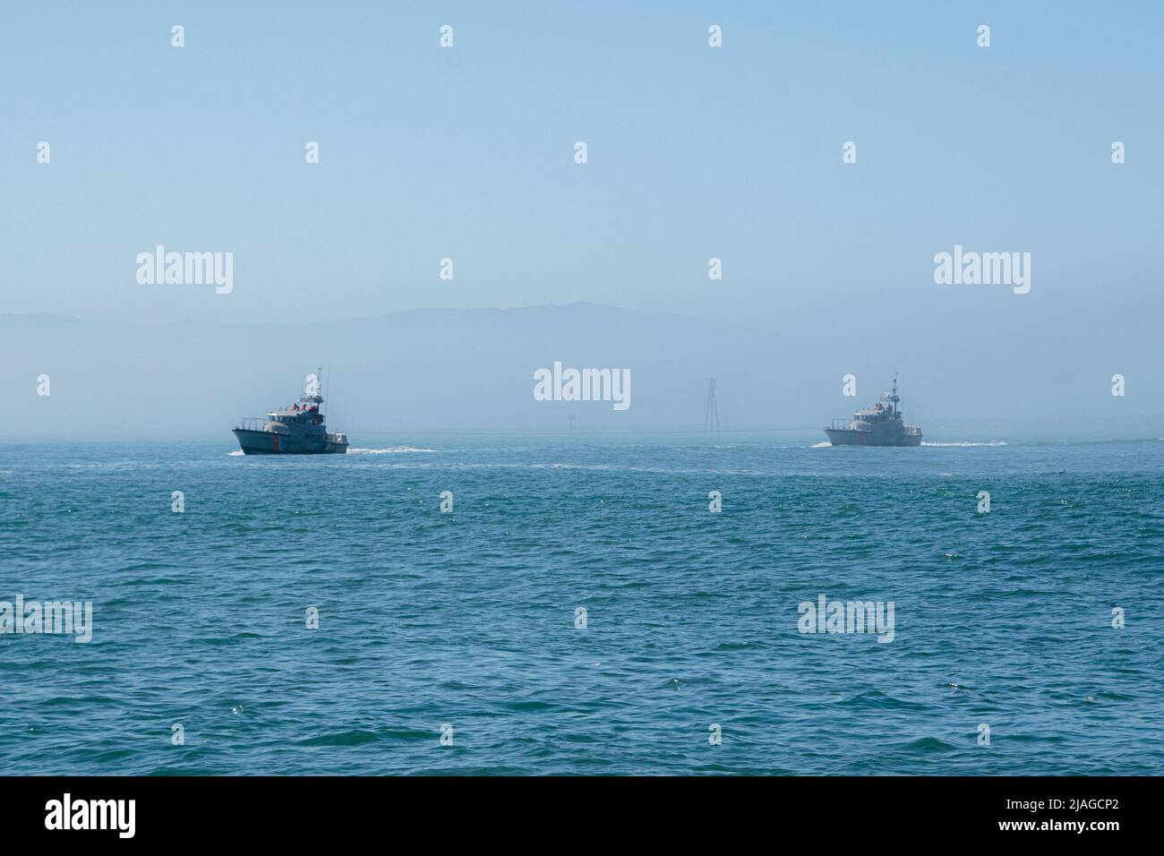 Deux navires de la garde côtière émergent du brouillard mordant le long de la côte du Pacifique. Banque D'Images