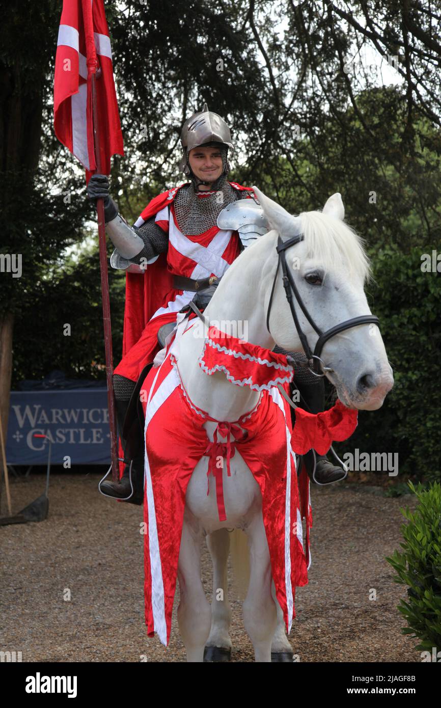 Chevalier dans une armure brillante sur un cheval blanc de retour au château de Warwick, Warwickshire, Angleterre, Royaume-Uni, 2022 Banque D'Images