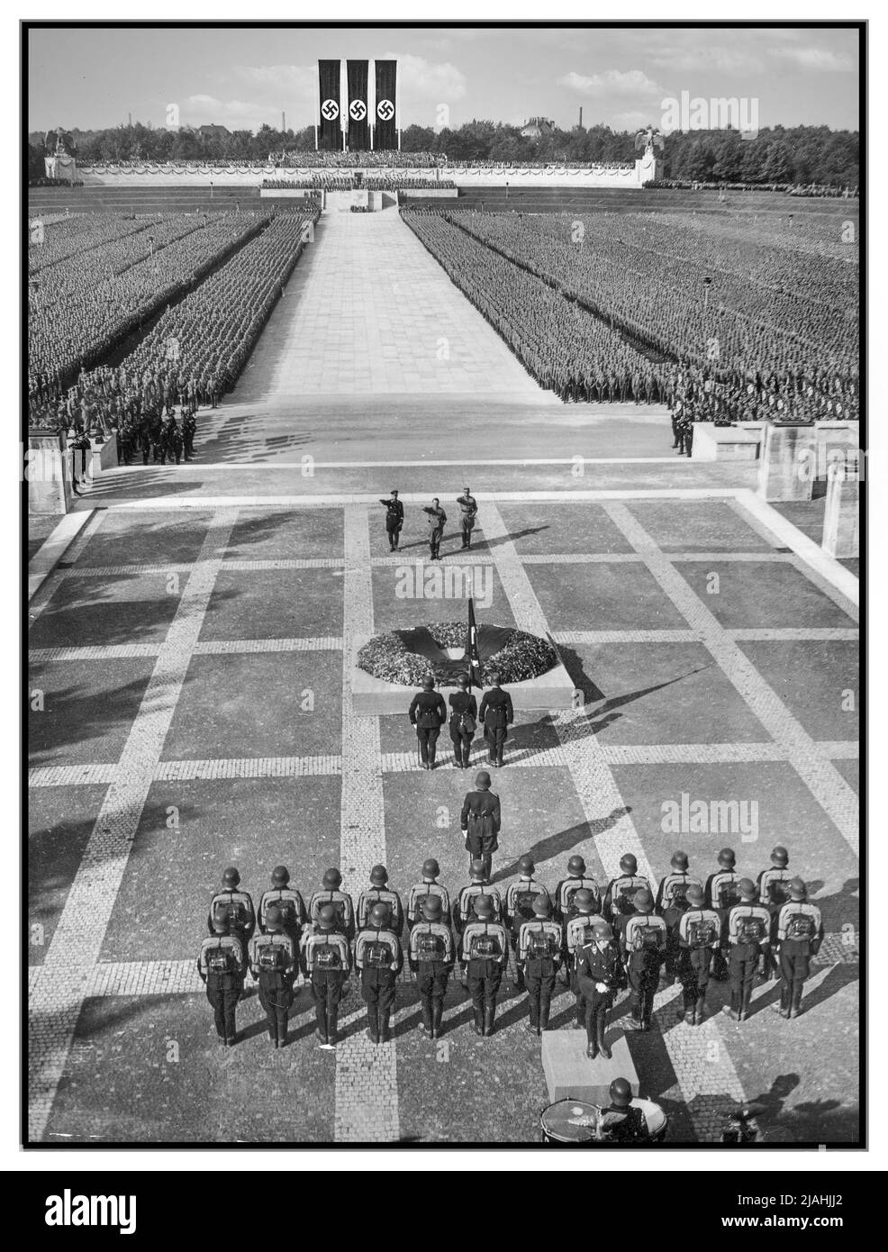 RALLYE DE NUREMBERG 1930s 1934 Adolf Hitler, Heinrich Himmler et Viktor Lutze sur les lieux de rassemblement du parti nazi pendant le rallye de Nuremberg 1934, le Congrès du parti nazi de 6th tenu à Nuremberg, 5 septembre–10, auquel ont assisté environ 700 000 partisans du parti nazi. Aussi des membres du parti paramilitaire branches Sturmabteilung (sa) et Schutzstaffel (SS), ainsi que le Blutfahne (drapeau de sang, drapeau de swastika cérémonial) et probablement son porteur SS-Sturmannführer Jakob Grimminger. : Le grand attrait de la S.A. et de la S.S. en face de la Führer dans le Luitpold Arena de Nuremberg. Allemagne nazie Banque D'Images