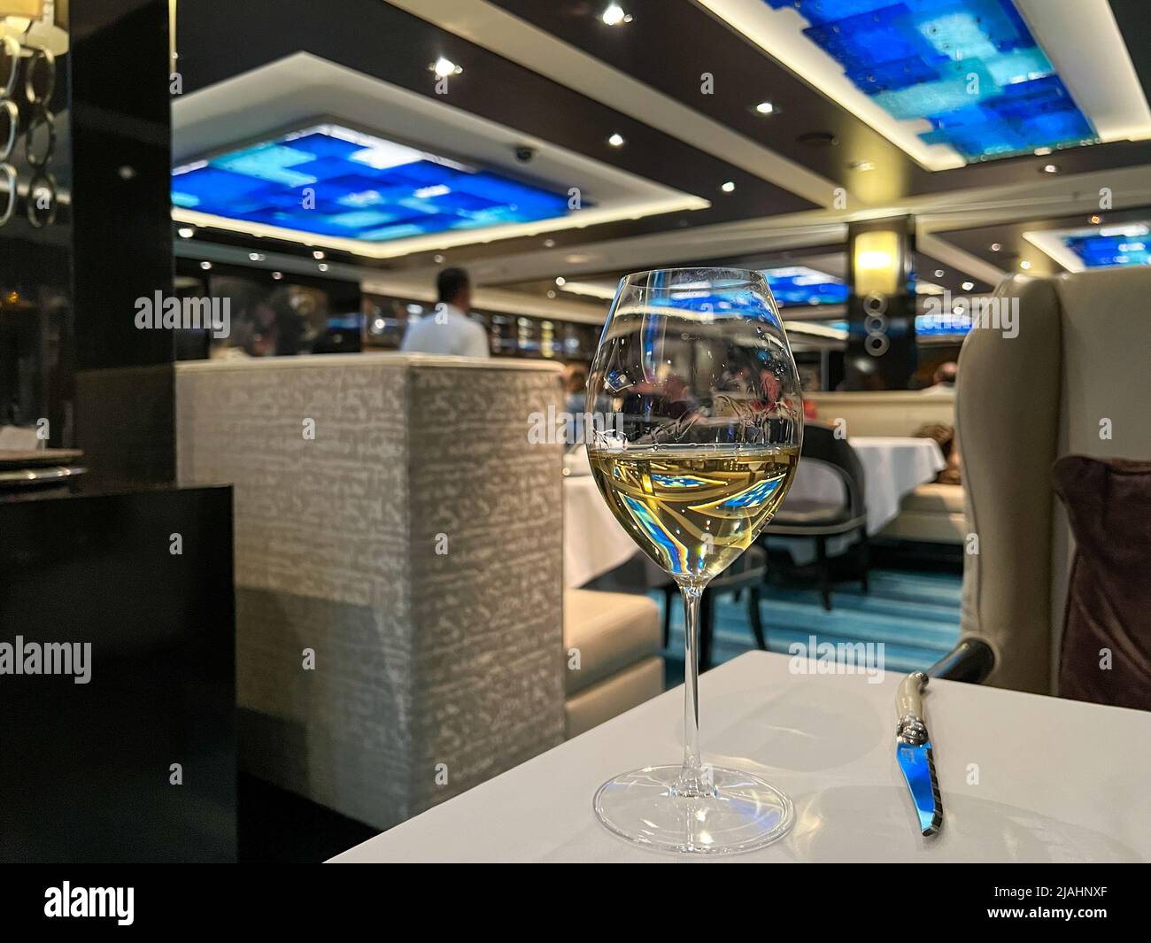 Orlando, FL USA-8 janvier 2022 : un verre de vin Chardonnay fraîchement versé dans la salle à manger Haven sur le bateau de croisière Norwegian Escape. Banque D'Images