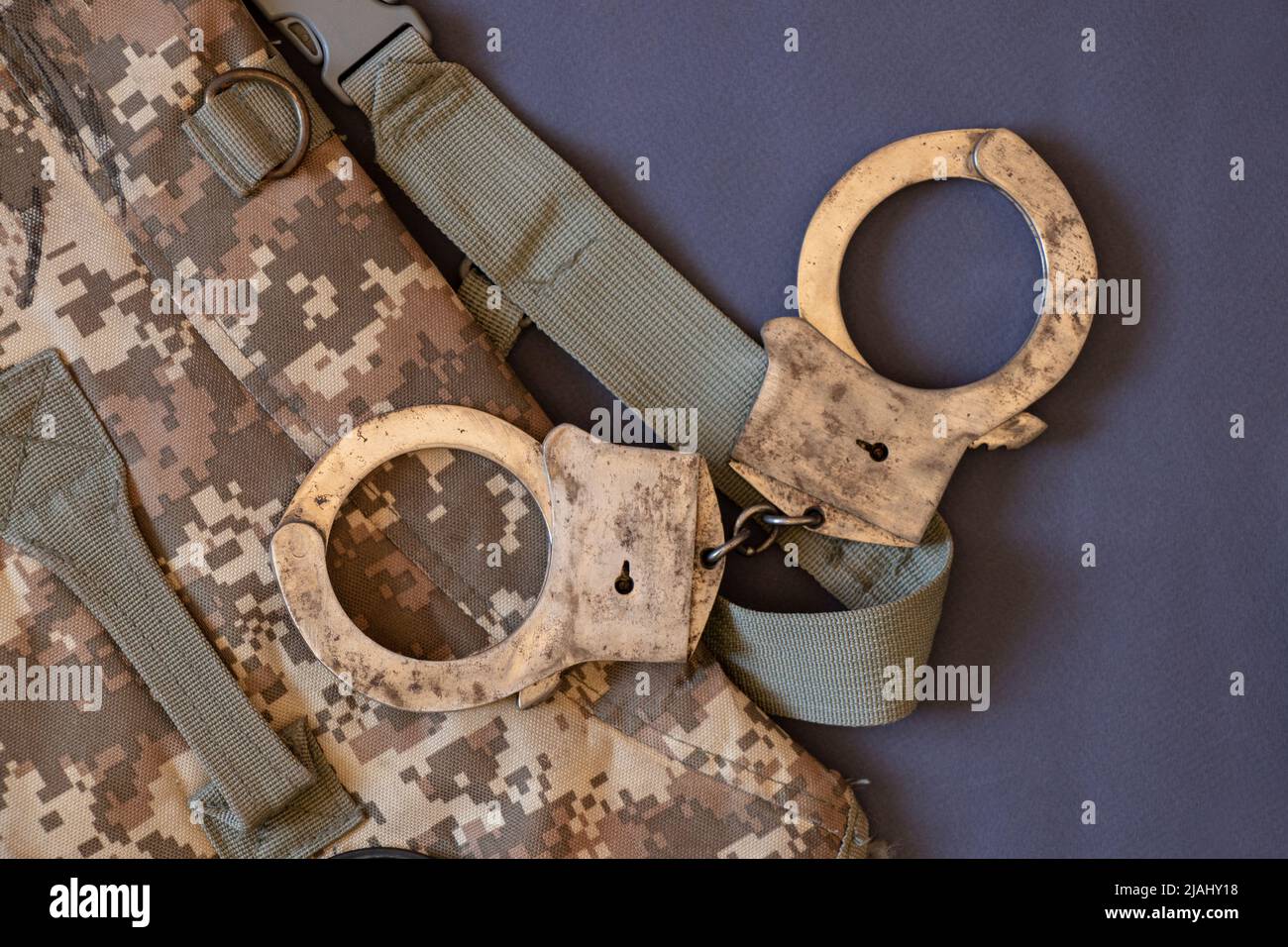 Les vieux menottes reposent sur un sac de camouflage , la loi et la justice Banque D'Images