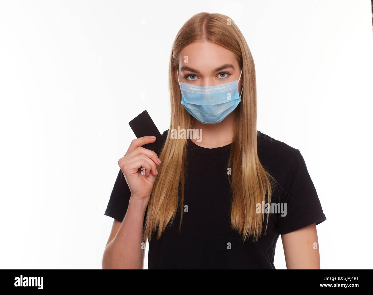 femme avec carte de crédit portant un masque médical isolé sur fond blanc. Photo conceptuelle, achats avec paiement sans espèces pendant la quarantaine. Banque D'Images