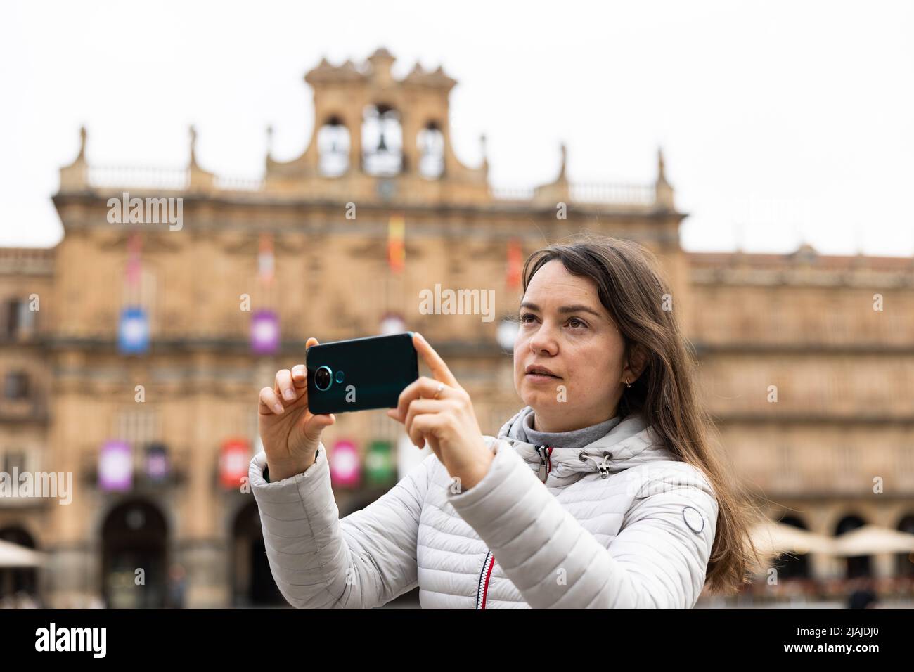 Une femme prend des photos sur son appareil photo pendant son voyage à travers la Plaza Mayor. Espagne Banque D'Images