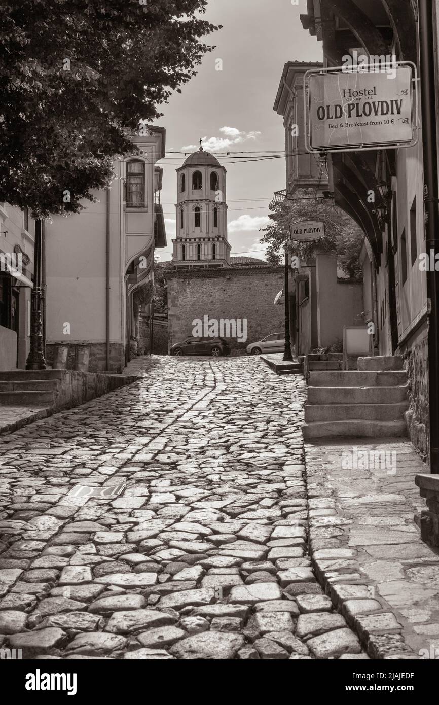Une auberge dans la rue pavée de la vieille ville de Plovdiv avec la Tour de St Constantine et l'église de Sainte-Hélène vue en sépia Banque D'Images