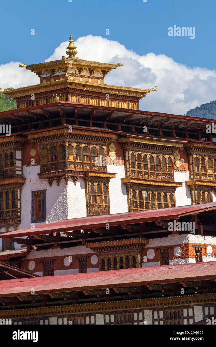 Le Punakha Dzong est vu à travers le Mo Chhu River dans le centre bouddhiste du Bhoutan tandis que les drapeaux de prières flottent à proximité Banque D'Images