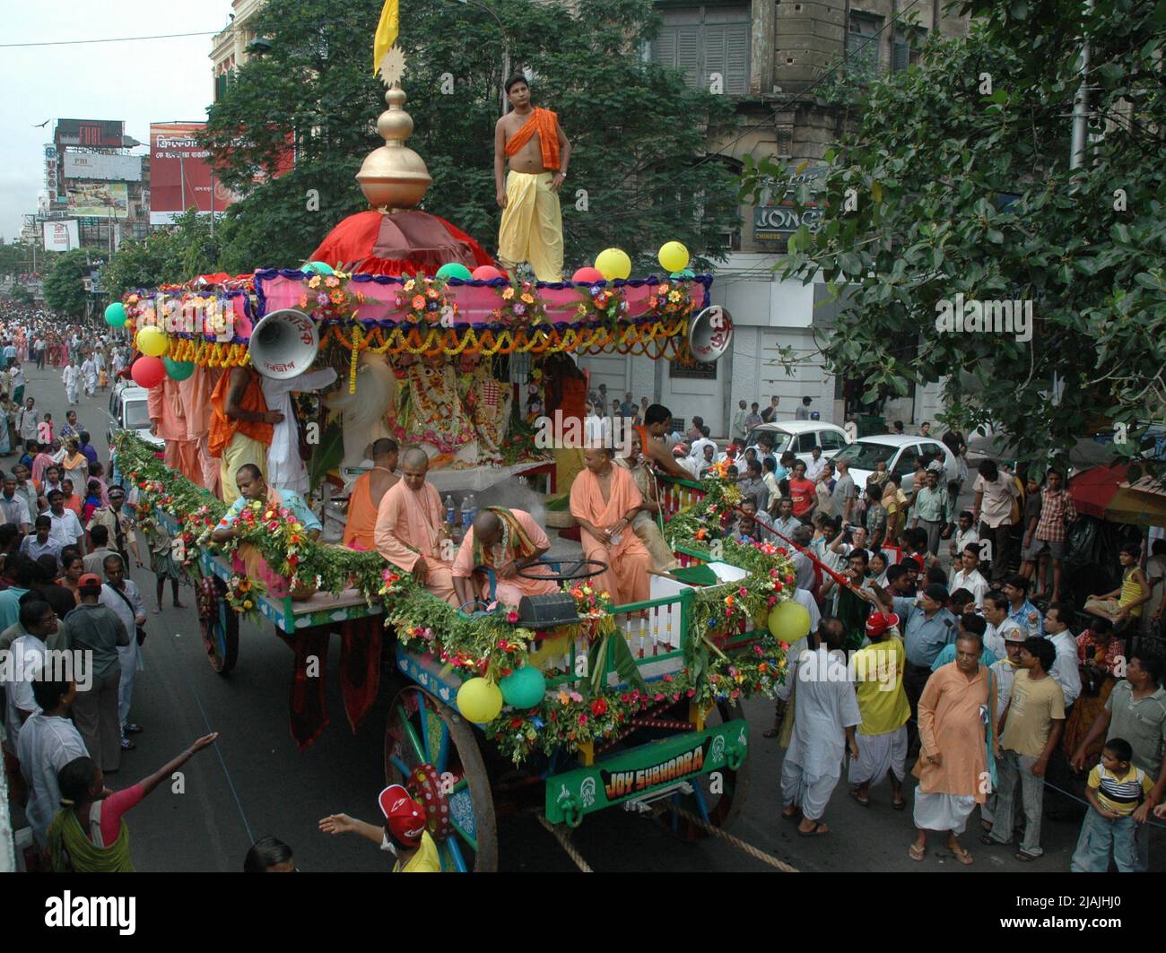 Les dévotés et les membres de la Société internationale pour la conscience de Krishna (ISKCON) marchent avec des chars à la diéité pendant le festival annuel de Rath Yatra. Chaque année, le Dieu hindou Krishna, son frère Balarama, et sa sœur Subhadra sont traditionnellement installés sur d'énormes chars ou des "serments" qui sont tirés par des dévotés dans une procession, ou "yatra" à travers la rue. Kolkata, Inde. 16 juillet 2007. Banque D'Images
