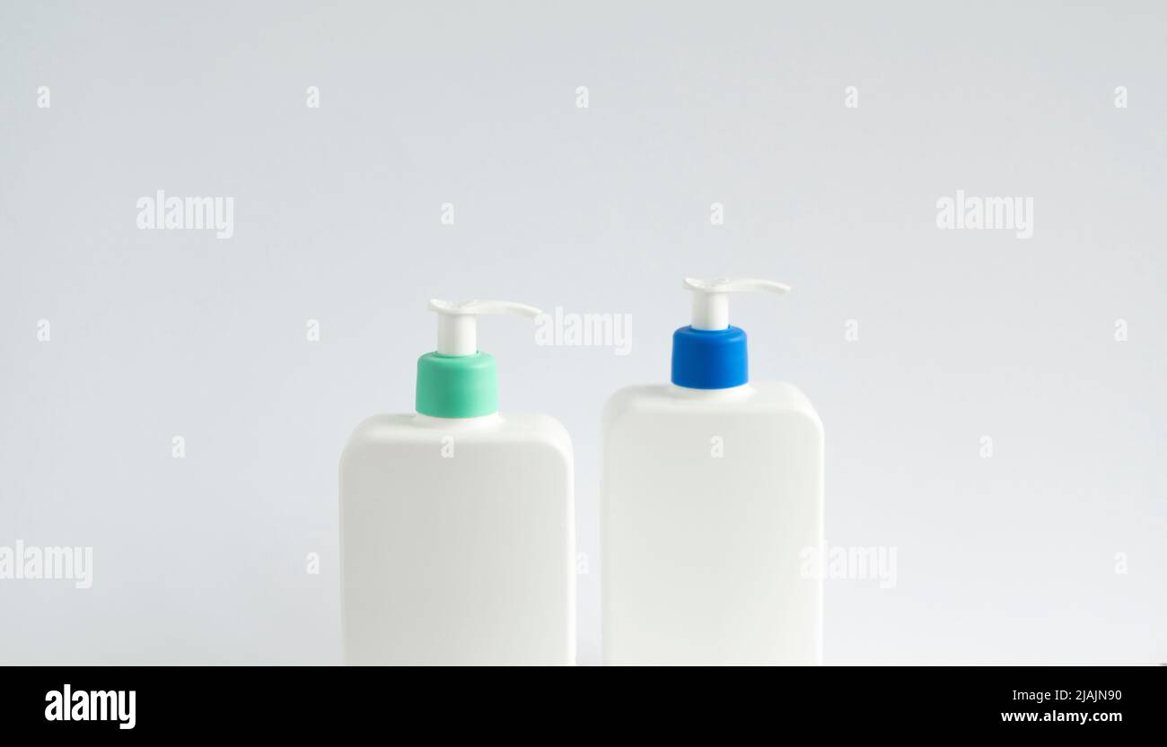 Deux flacons distributeurs blancs sans marque sur fond blanc. Maquette d'emballage cosmétique avec espace de copie. Banque D'Images
