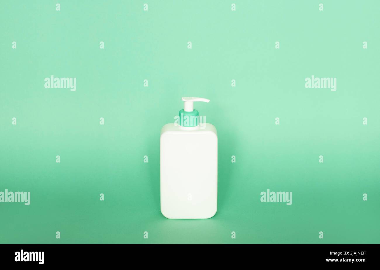 Grande bouteille en plastique blanc avec distributeur de pompe en tant que contenant liquide pour gel, lotion, crème, shampooing, mousse de bain sur fond rose. Banque D'Images