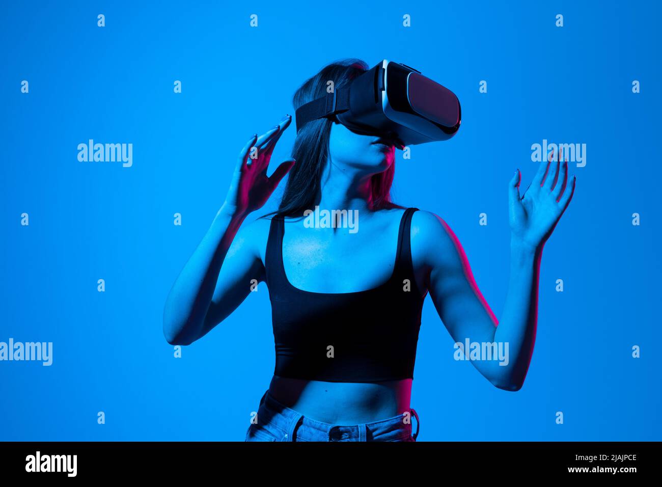 Jeune femme travaillant dans des lunettes VR sur fond gris.Architecte moderne utilisant des lunettes de réalité virtuelle sur le lieu de travail.Concepteur travaillant dans augmentée Banque D'Images