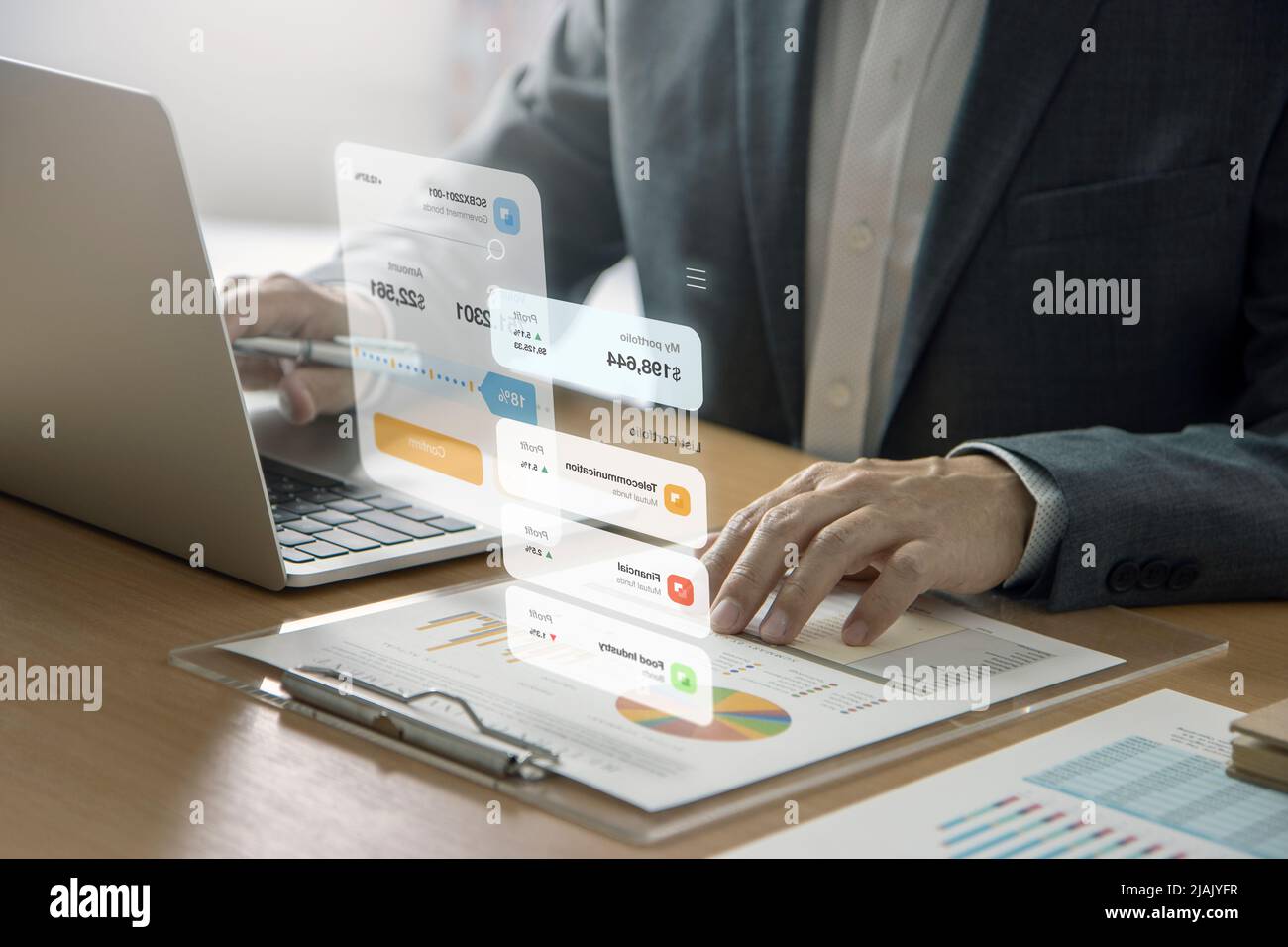 Homme d'affaires devant un ordinateur portable qui interagit avec un écran futuriste de réalité augmentée tout en analysant un retour sur investissement Banque D'Images
