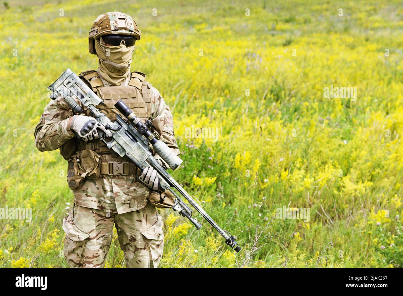 Soldat armé debout dans un champ de fleurs. Banque D'Images