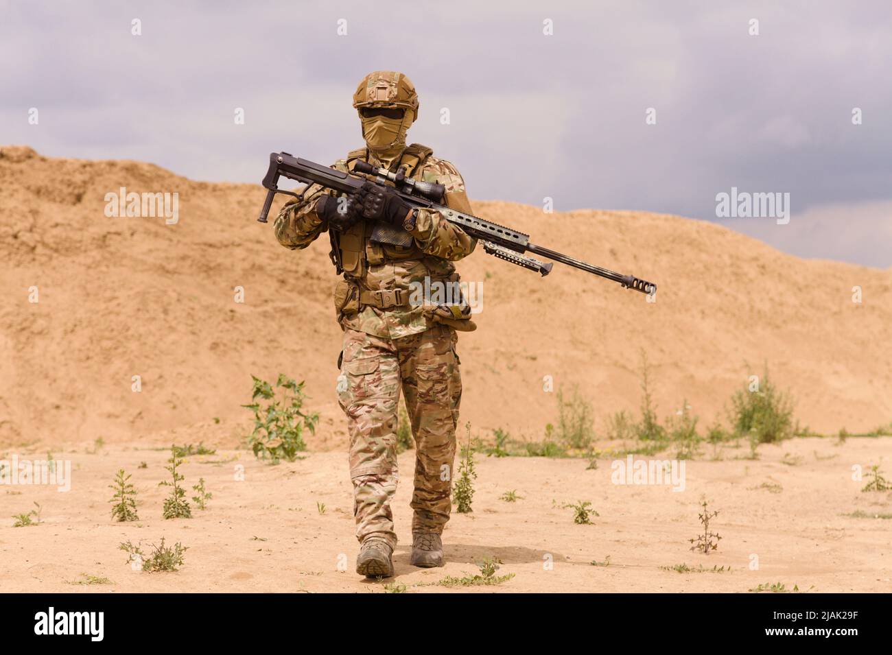 Soldat armé des forces spéciales à carabine dans le désert pendant une opération militaire. Banque D'Images