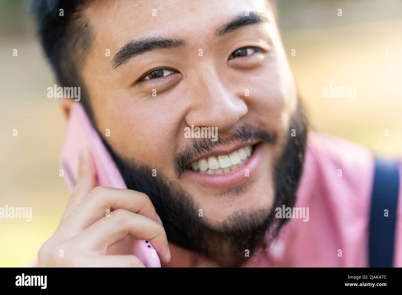 Gros plan d'un homme chinois souriant avec mobile. Banque D'Images