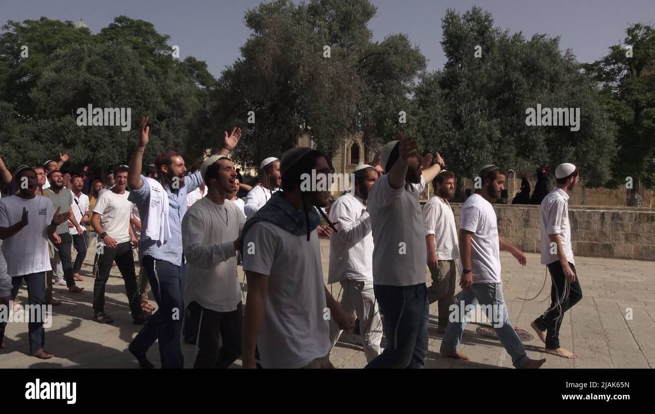 JÉRUSALEM, ISRAËL - 29 MAI : des policiers israéliens escortent un groupe d'Israéliens ultra-nationalistes en visite sur le Mont du Temple connu des musulmans sous le nom de Haram esh-Sharif (Sanctuaire Noble) pendant le jour férié israélien « Jérusalem Day » avant la « marche du drapeau » nationaliste juif dans la vieille ville de 29 mai 2022, à Jérusalem, en Israël. La marche du drapeau de Jérusalem marque l'anniversaire de l'unification de la vieille ville et de Jérusalem-est en 1967. Banque D'Images