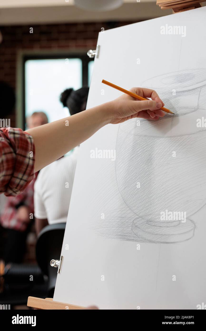 Artiste homme dessin vase croquis sur toile blanche travaillant à l'illustration graphique en utilisant la technique d'esquisse pendant l'école d'art. Peintre étudiant participant à la leçon de créativité pour la croissance personnelle Banque D'Images