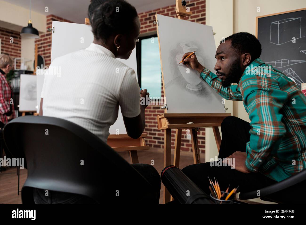 Peintre collègues assis devant sur toile dessin vase modèle à l'aide de crayon graphique en studio de créativité. Une équipe diversifiée qui s'adresse à des cours d'art développe de nouvelles compétences artistiques pour la croissance personnelle Banque D'Images
