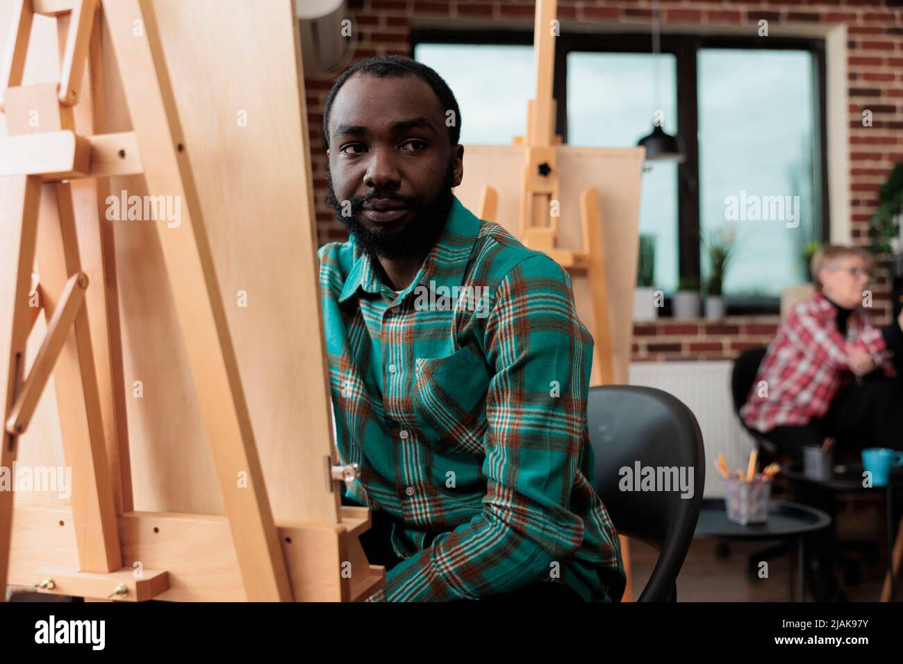 Portrait de l'étudiant souriant attaquant classe d'art développement de nouvelles compétences artistiques pour la croissance personnelle apprentissage de la technique graphique en studio de créativité. Peintre homme dessin vase modèle. Concept créatif Banque D'Images