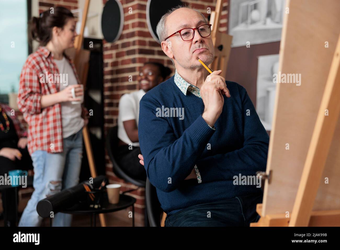 Portrait d'un vase de dessin étudiant âgé sur toile blanche à l'aide d'un crayon graphique en studio de créativité. Diverses équipes de cours d'art de développement de nouvelles compétences artistiques pour la croissance personnelle Banque D'Images