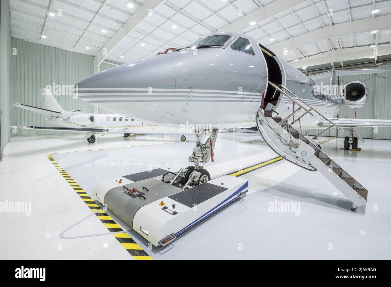 Deux petits avions à jet privés garés dans un hangar - photo de stock Banque D'Images