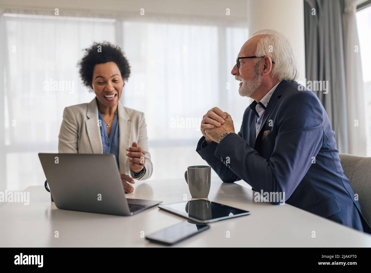 Femme d'affaires confiante discutant du plan d'affaires avec le cadre supérieur. Les professionnels masculins et féminins planifient pendant la réunion. Ils sont assis au bureau Banque D'Images