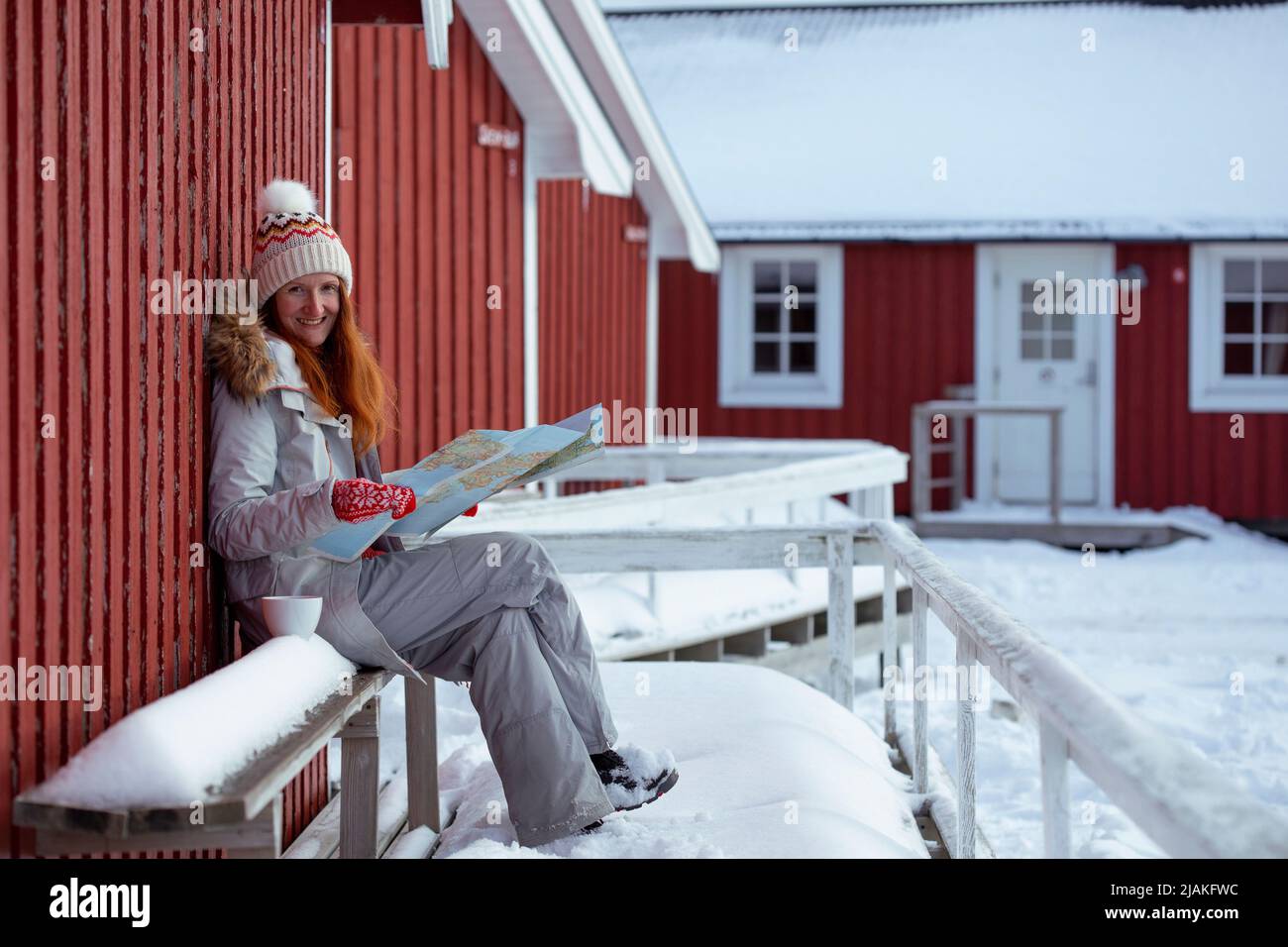 Fille de tourisme se trouve à proximité de rorbu avec une carte sur les îles Lofoten. La Norvège Banque D'Images